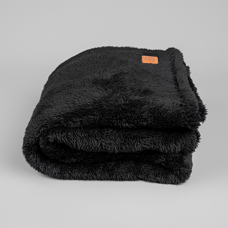 Black That ONE Blanket folded on a neutral background